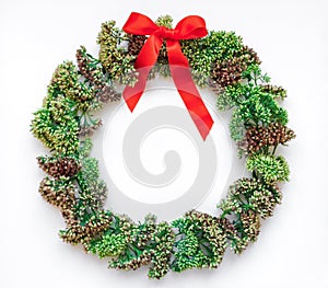 Green floral round wreath frame on white background. Flat lay, top view, view from above. Autumn or winter decoration