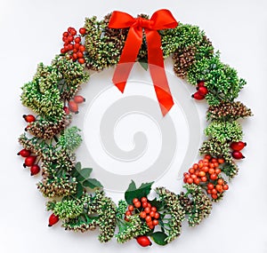 Green floral round wreath frame on white background. Flat lay, top view, view from above. Autumn or winter decoration