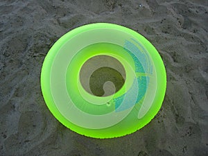 Green flotation ring on the sand