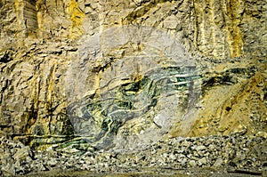 Green folded rock formation inside mountain wall