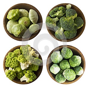 Green food on a white background. Brocoli, Roman cauliflower, squash and Brussels sprouts cabbage in a wooden bowl.