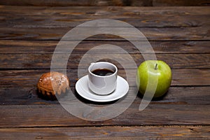 Green fresh apple and coffee in white cup with cupcake