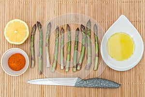 Green fresh asparagus for cooking on wooden table on kitchen close up. Healthy diet vegan food