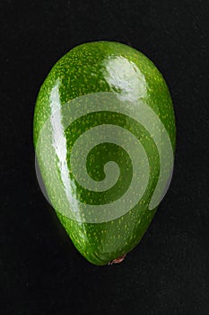 green fresh avocado over black background close-up