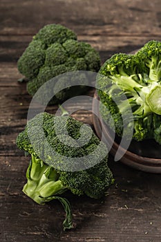 Green fresh broccoli on old wooden background. Ripe vegetables for diet and healthy eating
