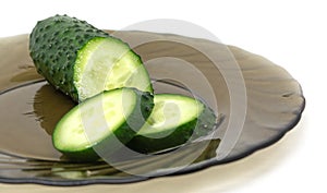 Green fresh cucumber sliced on glass plate