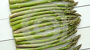 Green fresh and healrhy asparagus placed on a white wooden table. Top view. Close up.