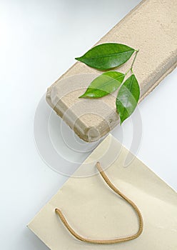 Green fresh leaves on packaging white background Eco friendly, paper recycling, zero waste, natural products concept. Copy space
