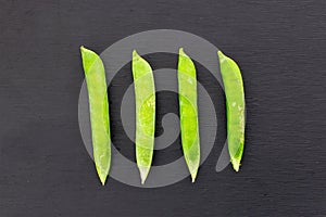 Green fresh pea pod parallel row of vegetables on a black background contrasting design set