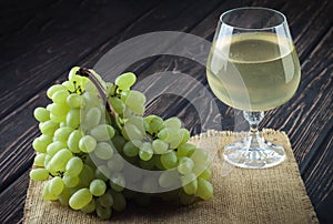 Green fresh ripe grapes and a glass of white wine