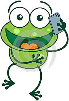 Green frog talking on a smartphone
