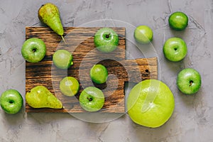 Green fruit, apples, lime, pear,oroblanco on a cutting board. Collection of fruits