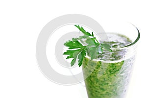 Green fruit and vegetable smoothie with a sprig of parsley in a transparent glass mug on a white background. healthy diet. food