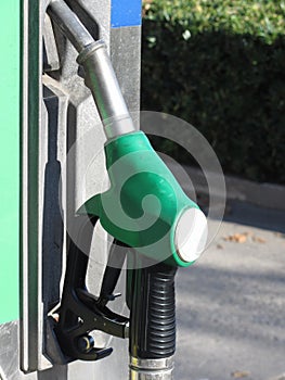 Green fuel pistol on gas station . Unleaded petrol at the pump station