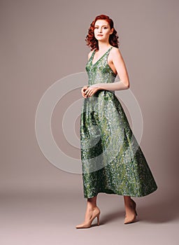 Green full-length evening dress. Beautiful model wearing emerald high heels, modern feminine look for an event