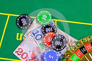 On green gaming table are roulette Georgian banknotes lari a poker chips.