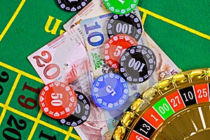 On green gaming table there are roulette, Georgian banknotes in of lari poker chips.