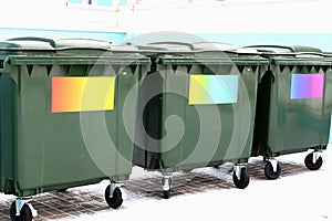 Green garbage cans without labels with colored stickers