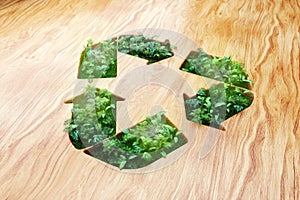 Green garbage recycling sign covered with green plants on wooden background. Concept of saving the planet, modern design, magazine