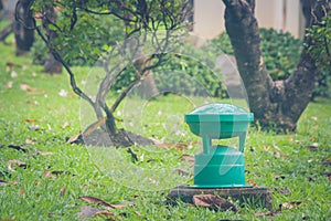 Green garden lamp on green grass in public park.