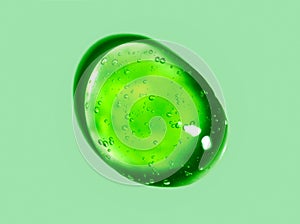 Green gel drop. Liquid cream gel cosmetic smudge texture on green background