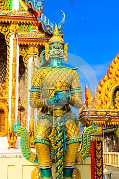 Green giant symbol of Thai religion standing front of temple