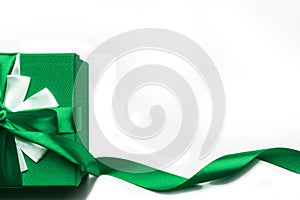 Green gift box with bow and ribbon on a white background, isolated image