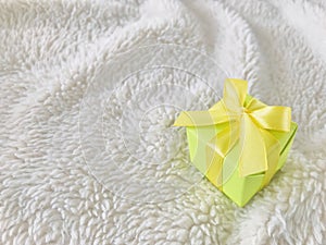 Green Gift box on fur background.