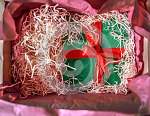 green gift box hidden in a box with shavings.