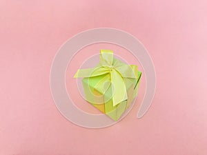 Green gift box on pink background.