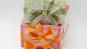 Green gift box on the pink box with bows for a celebration