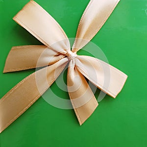 Green gift paper background with golden ribbon and bow. Surprise!