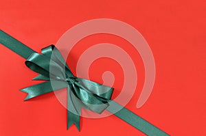 Green gift ribbon bow corner diagonal red paper background