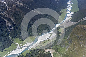 Green glades and shoals in pebbly riverbed at winding Wilkin river, from above, New Zealand