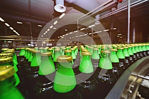Green glass beer bottles on a conveyor belt in the background of a brewery.