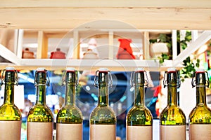 Green glass bottles of wine in line on wooden shelf, bar interior design, wine tasting concept, nightlife style, winery production