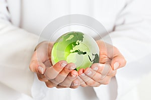 Green glass globe in hand