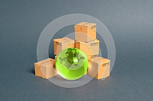 Green glass planet globe and a pile of cardboard boxes. Business and industry, transport infrastructure. The concept of commerce