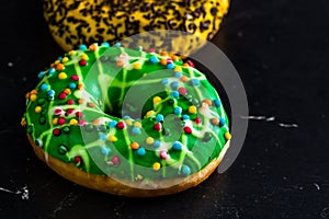 Green glazed donut with sprinkles isolated. Close up of colorful donut