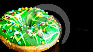 Green glazed donut with sprinkles isolated. Close up of colorful donut