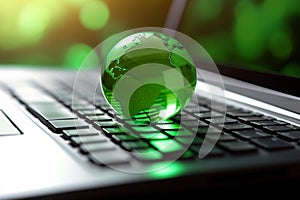 Green globe on a laptop keyboard with green bokeh background