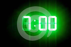 Green glowing digital clocks in the dark show 7:00 time