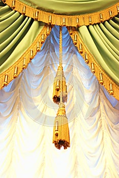 Green and gold colored curtains with tassels