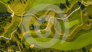 a green golf course from the air with trees in the background