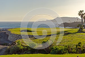 Green golf with flag and hole facing Atlantico ocean in Santa Cr photo