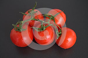 Green goods Tomatoes on a dark background with red tomatoes branch