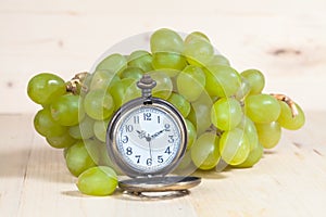 Green grape and old pocket clock