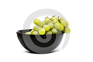 Green grapes in a black plate on a white background