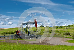 Green grass, blue sky, and pumpjack