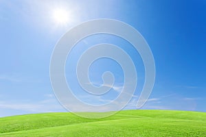 Green grass field and beautiful blue sky with clouds background.